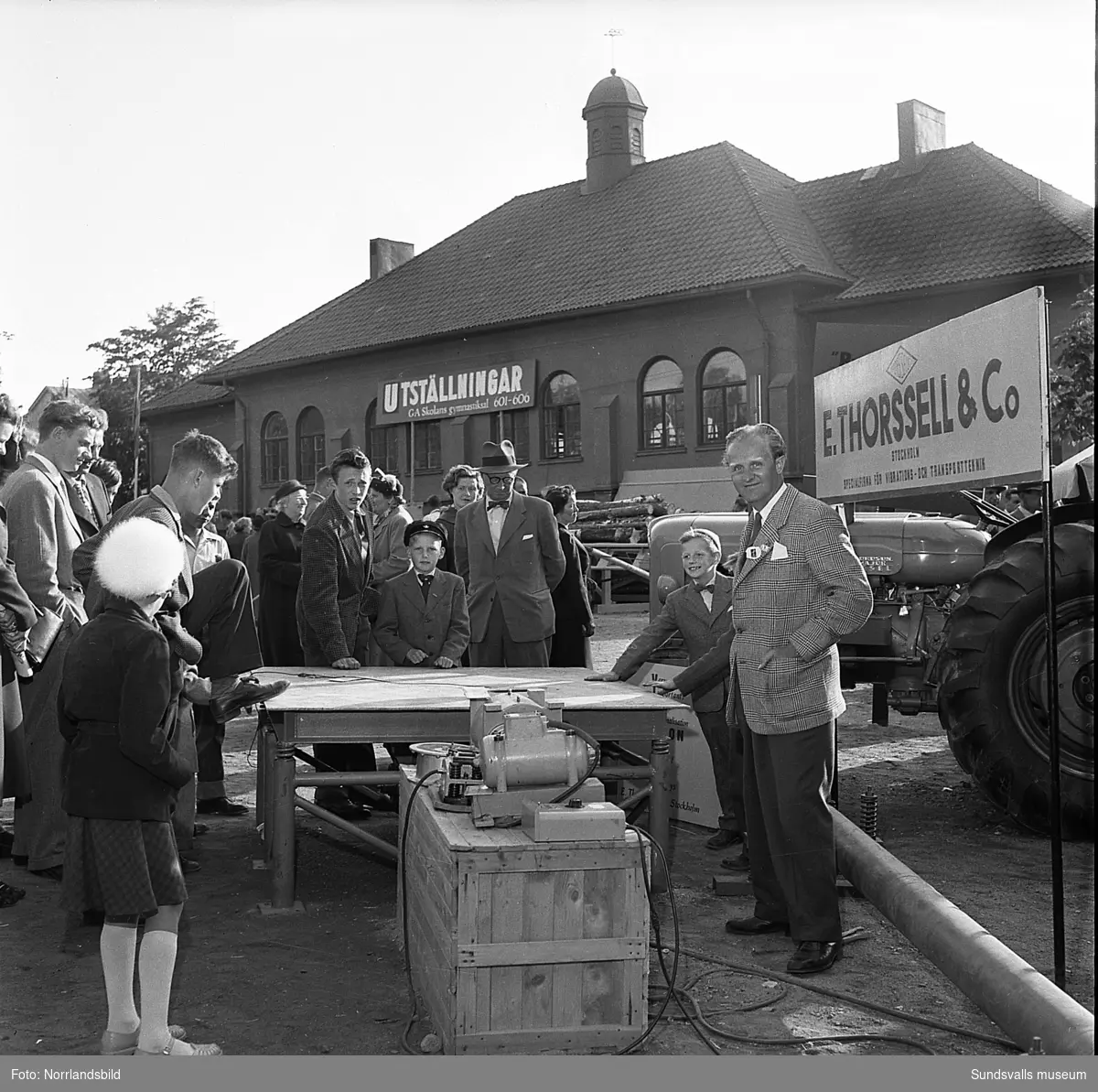 Sundsvallsmässan 1954, i en monter vid GA-skolan visar E. Thorsell & Co traktorer och maskiner. Fotograferat för Bydalens mekaniska.
