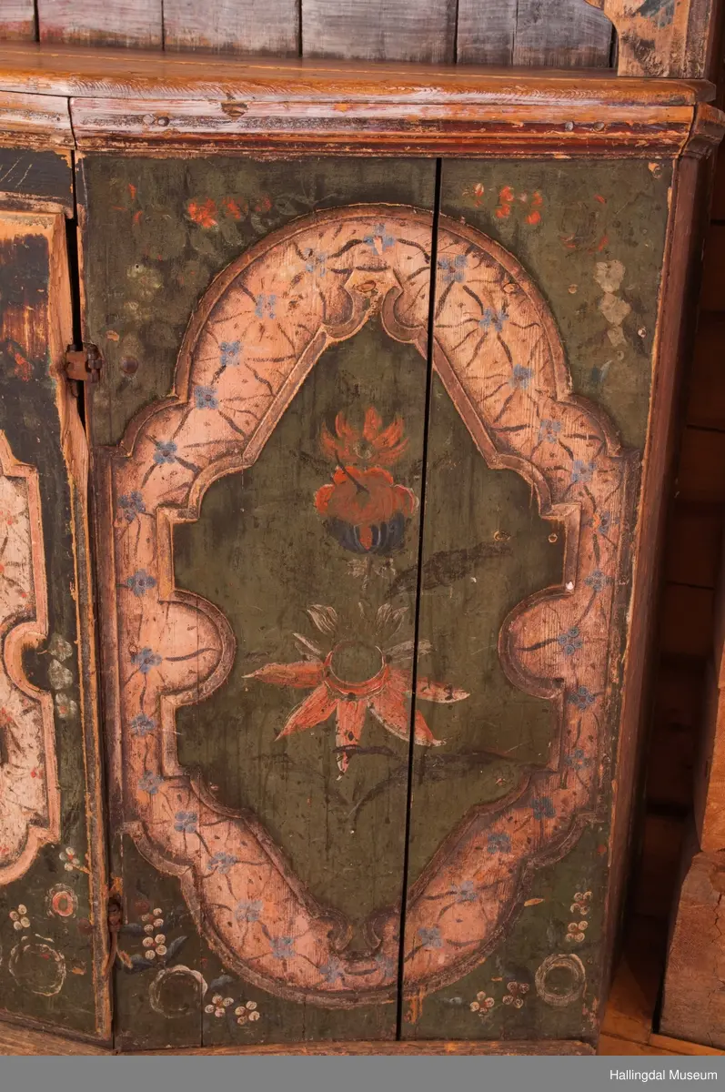 Marmorert toppstykke over felt med fem fyllinger.  Feltet grønnmalt med røde og hvite blomster.  Fyllingene, hvit bunn, sortmalte bokstaver og tall:  Anno 1796 H. Sata.  Overskapet har to hyller med lister og en smal hylle med profilert kant.  Bakveggen hvitmalt med rester etter mørkere undermaling, sideveggene marmorert.  Underskapet tredelt, fremspingende midtparti som er dør.  Fyllinger på de tre delene.  Grønn bunnfarge.  Slitt rosemaling, hvitt og rosa.  Profilert gulvlist.  Nøkkelhull med beslag og defekt lås av jern.  En hylle innvendig.