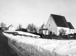 Trondeneskirka med snøskavler i forgrunnen. Til venstre kirk