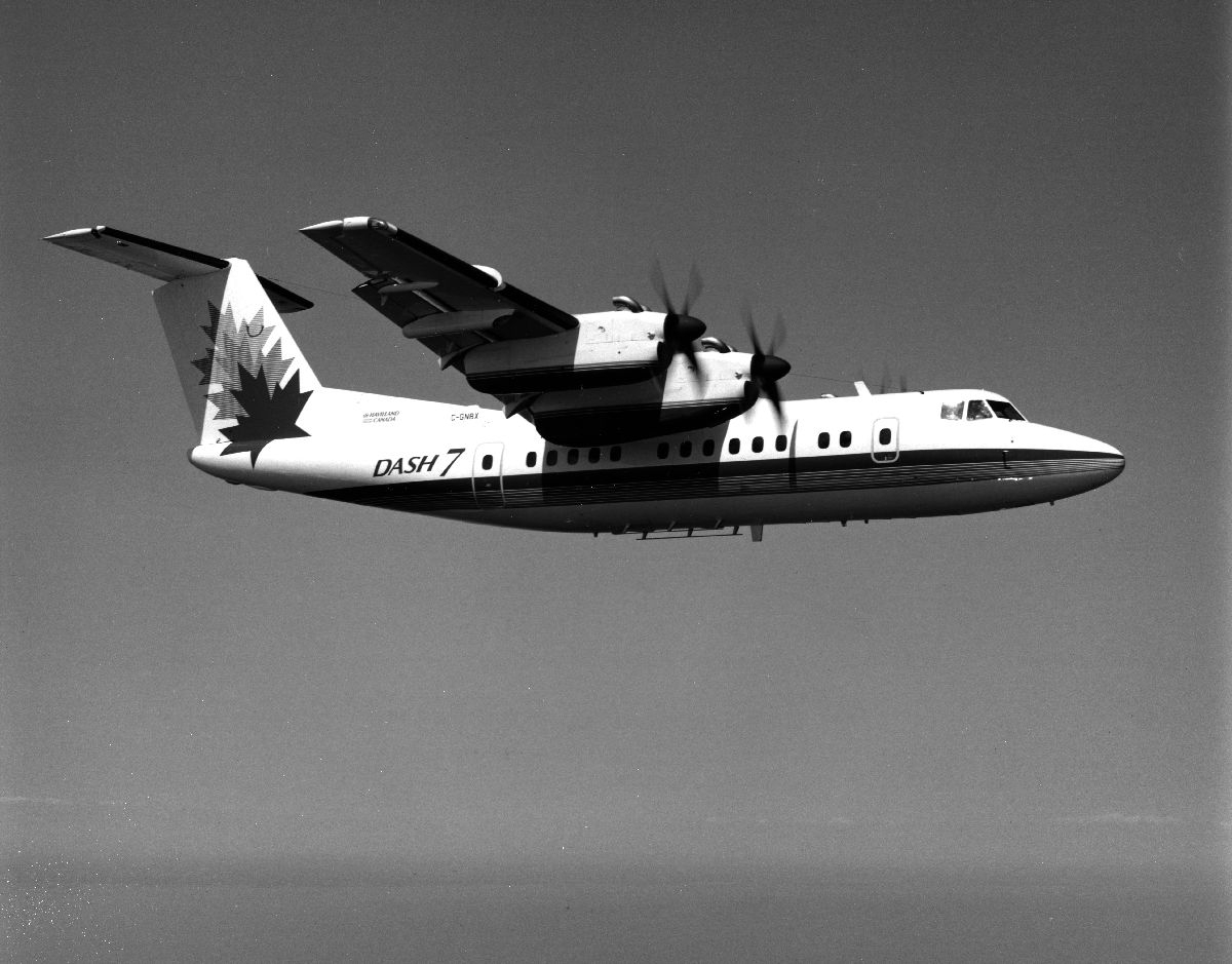 Luftfoto. Et fly De Havilland Canada, DHC-7, DASH7 ute på demo flyvning i fabrikkens logo.