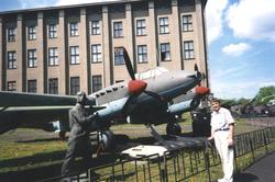 Landskap. En person har tatt oppstilling foran et fly og en 