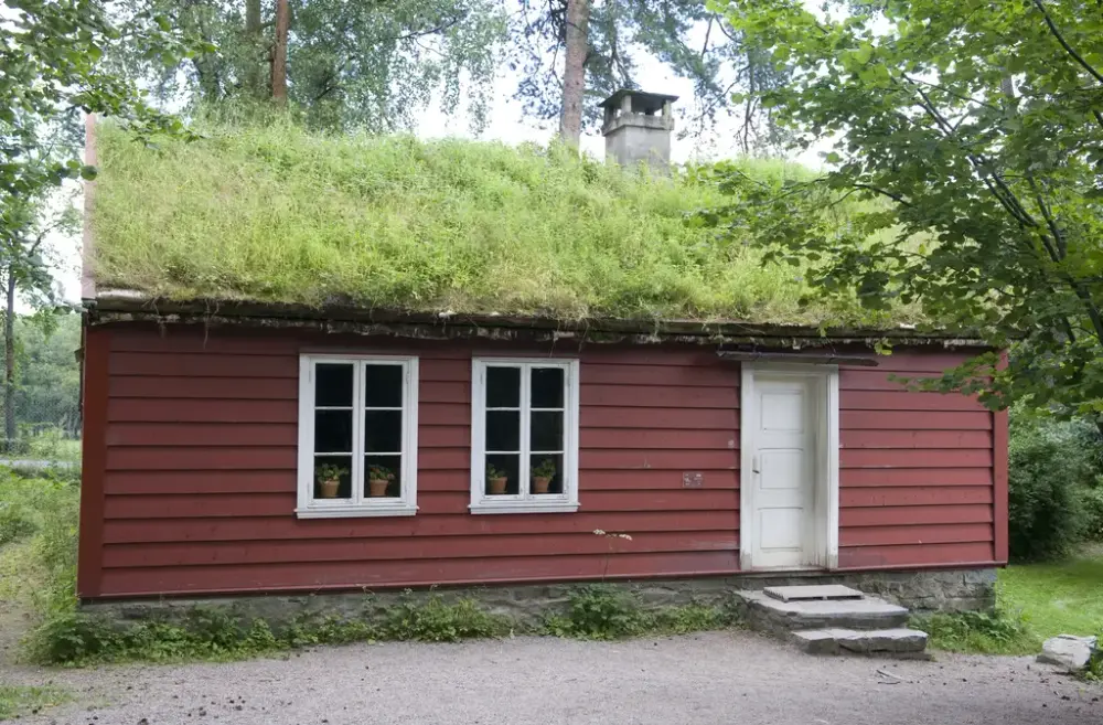 Rød skolestue med gress på taket.