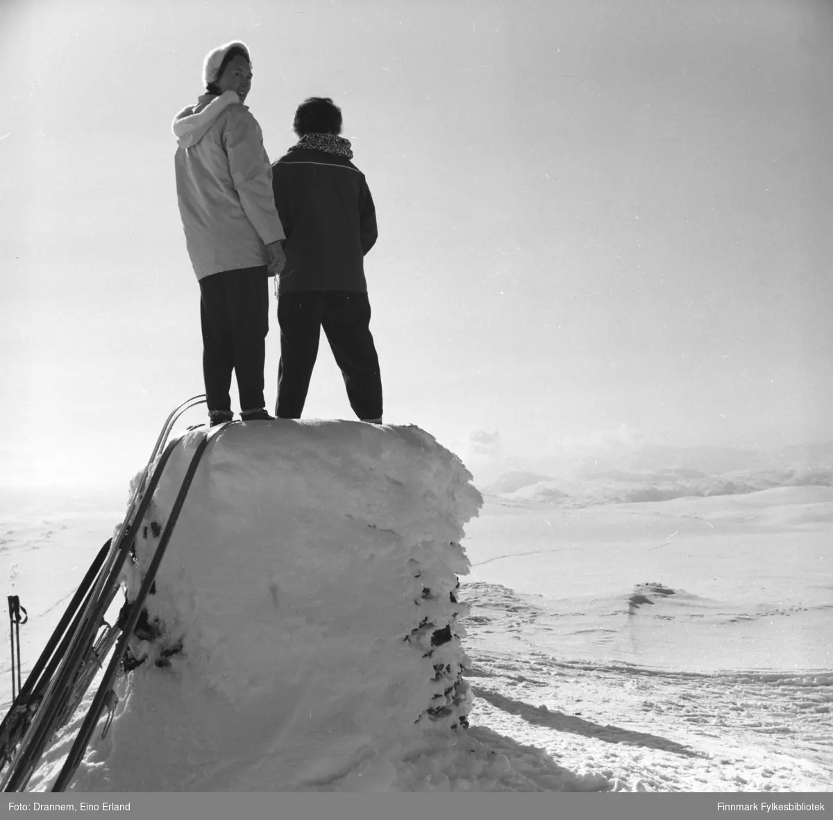 To damer står på et snødekt sylinder-formet byggverk. Jenny Drannem til høyre på bildet, den andre er ukjent.