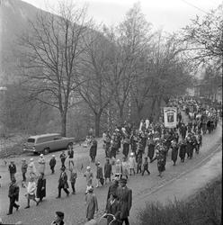 Tog med korps og faner ved kirkesvingen.