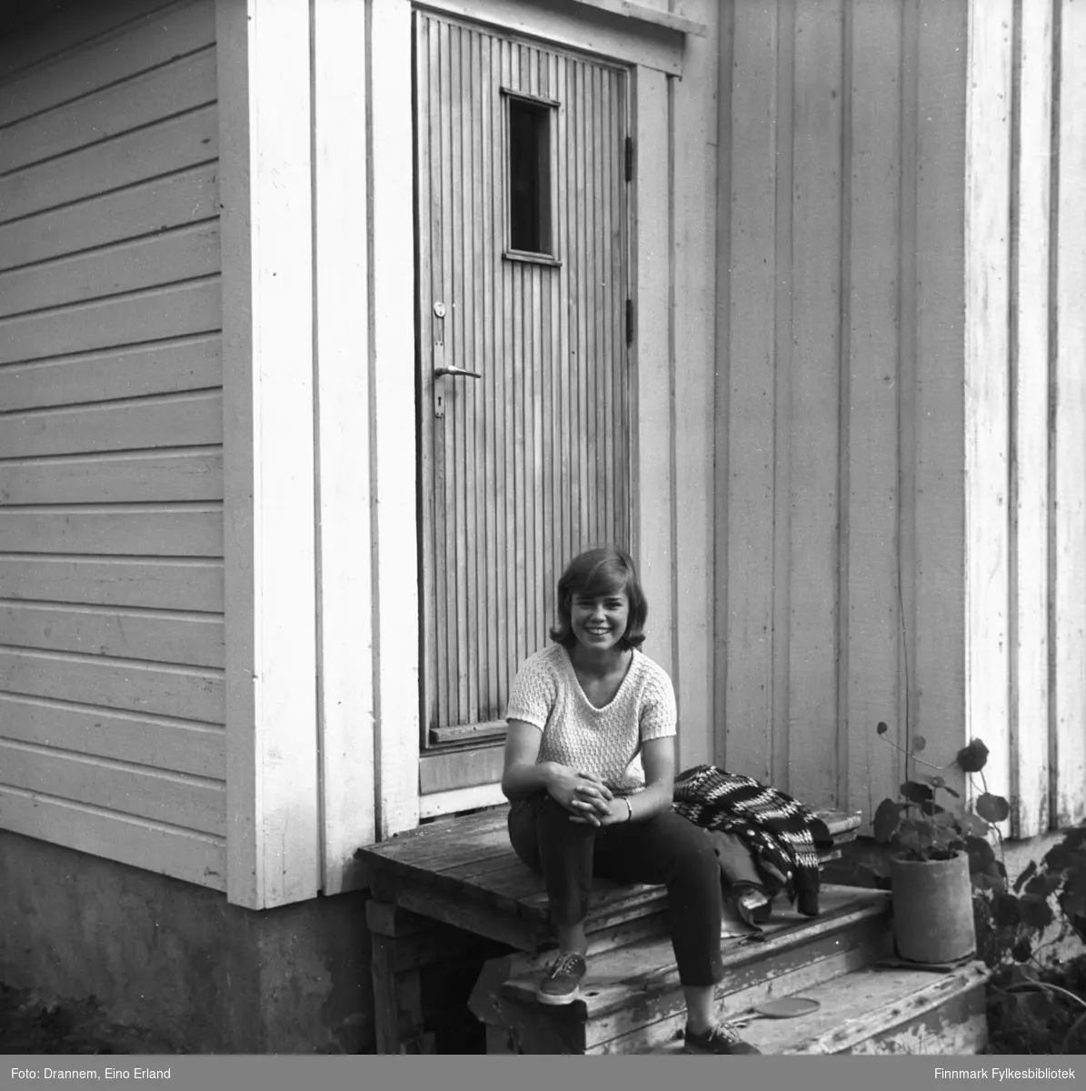 Marit Gabrielsen sitter på trappa foran en bolig i Neiden en sommerdag.