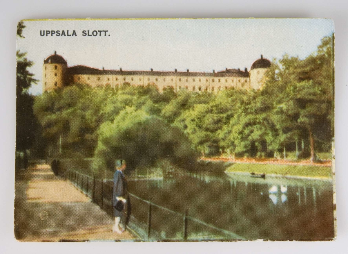 Rektangulärt bokmärke, glansbild, med färgtryck förställande Uppsala slott och Svandammen, med text Uppsala Slott. Skrivet med kulspetspenna på baksidan Sago-konst Nr 1.