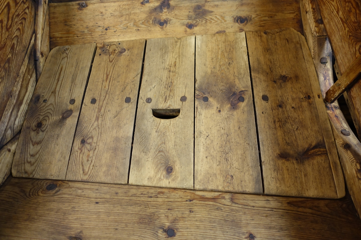Tilja består av fem planker festet til et spikerslag med trenagler. I den midterste planken er det et hull til handtak.