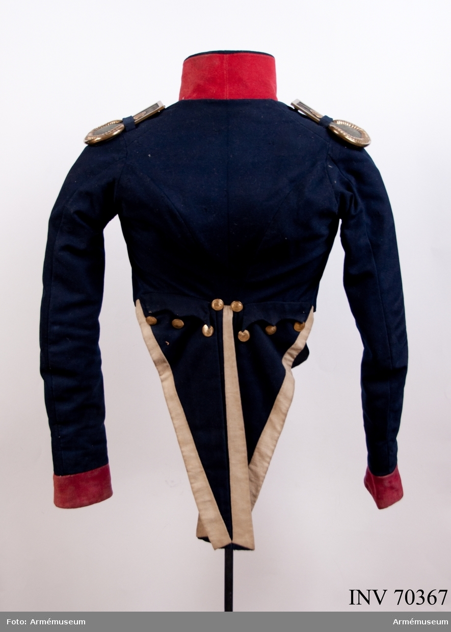 Grupp C I.
Frack av mörkblått kläde med röd krage och ärmuppslag, med ordningsmans distinktion (primaries) på kragen.