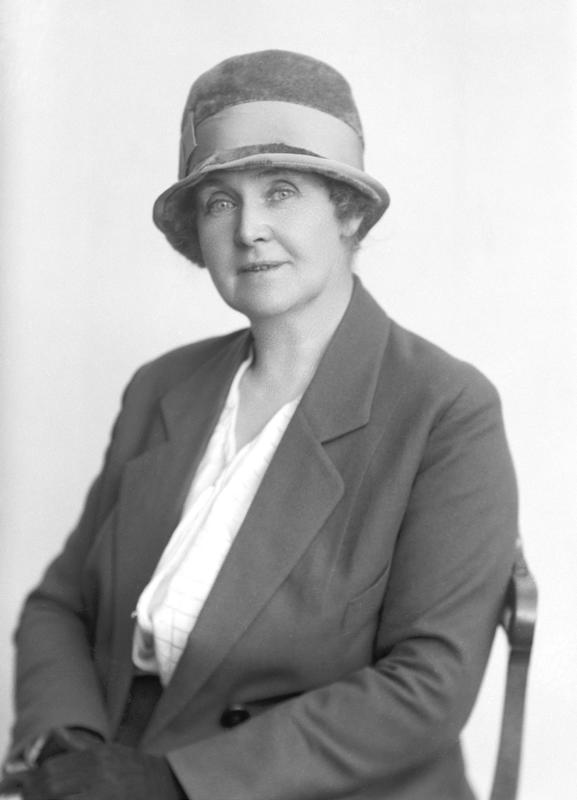 Portrett av en kvinne med hatt og frakk.