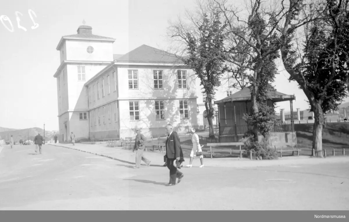 Kristiansunds Offentlige Høgre Allmenskoles (KOHAS) bygning - seinere Langveien Ungdomsskole, sett fra krysset Langveien/Skolegata. Musikkpaviljongen i parken sees i forgrunn. Bildet er datert Juli 1941. Nordmøre Museum