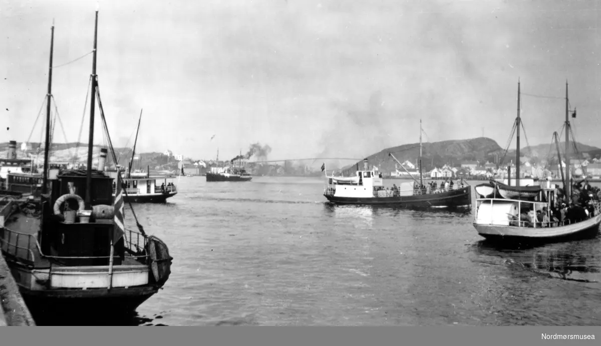 Fra Storkaia ser vi mange rutebåter og "lokale rutebåter". De "lokale rutebåtene" gikk kun til for eksempel Møstavågen eller Bolga. Fra venstre i bakgrunnen ser vi Gomalandet, Nordsundet med Nordsundbrua som ble bygd i perioden 1936-1939, og Nordlandet med Bjørnehaugen til høyre. Fra Nordmøre Museum sin fotosamling.
