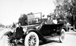 Georg Sverdrup bak rattet i sin bil med to kvinnelige passas