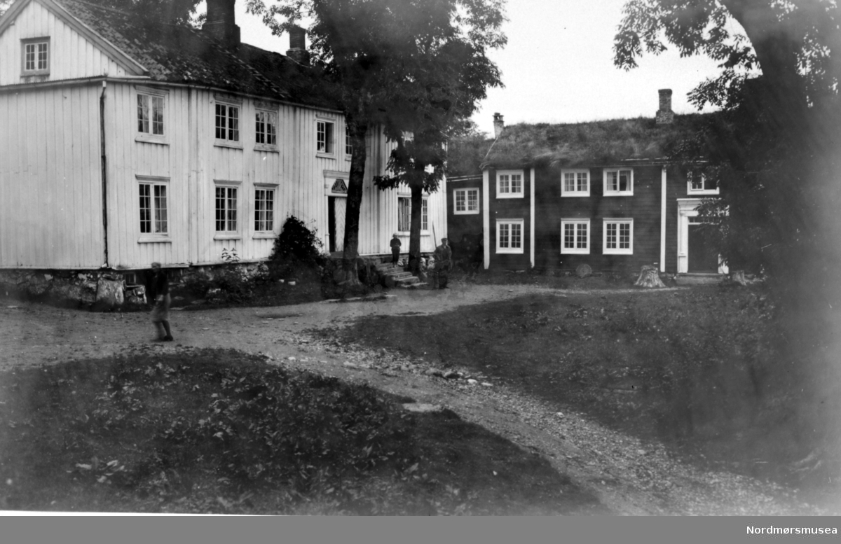 Postkort: 639 ";Gimnes gård. Nordmør. Eneret G. Sverdrup 1934"; Foto fra Gimnes gård i Gjemnes kommune, hvor vi ser fra to gårdshus foran et tun. Fra Nordmøre Museums fotosamlinger. Reg: EFR

