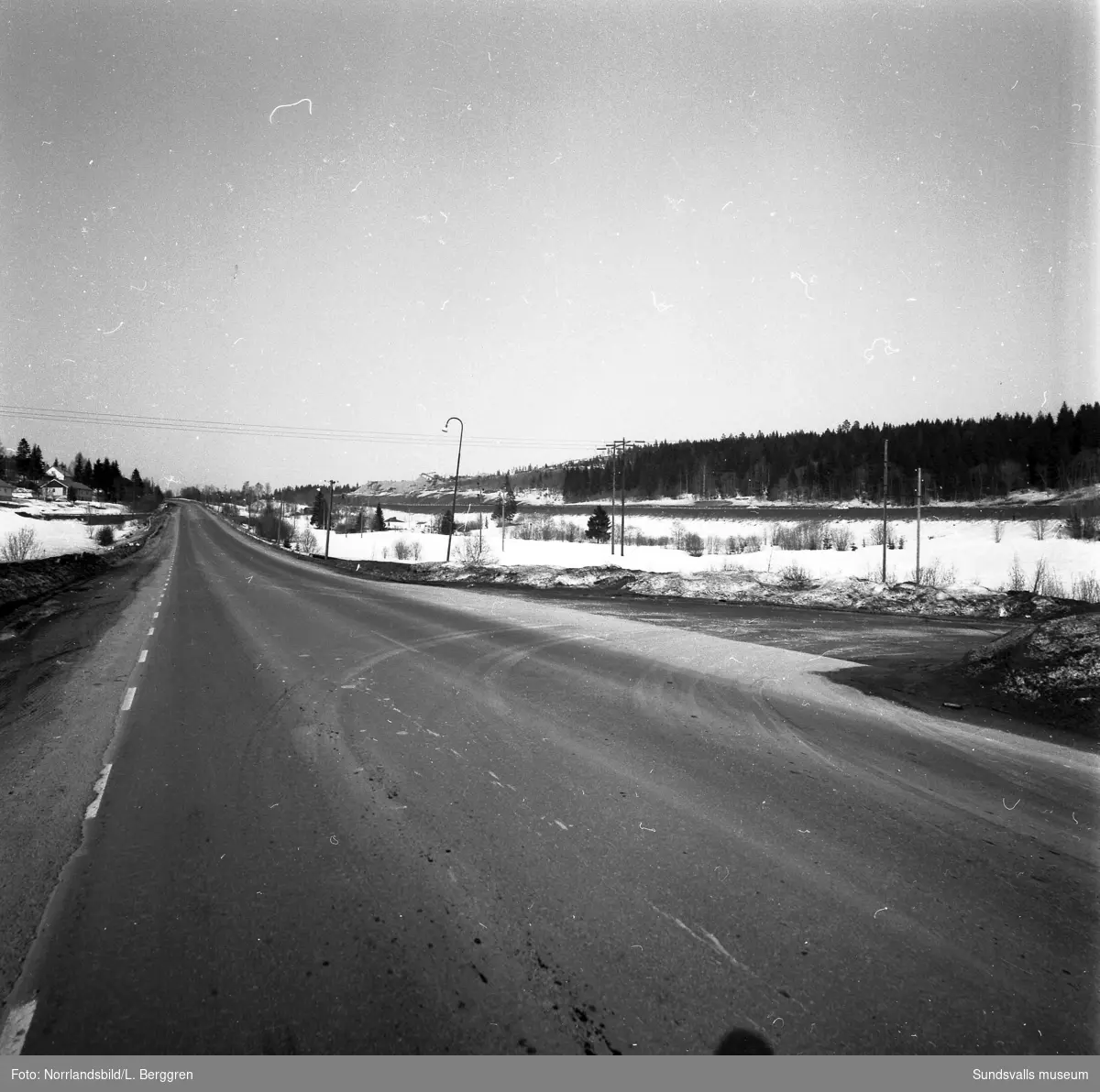 Vy norrut vid Råstabacken på Norra Vägen vid Valknytt, Bosvedjan. Äldre bebyggelse syns i området mellan Norra vägen och motorvägen där det numera är industrifastigheter. Råstakrossen syns uppe på krönet.