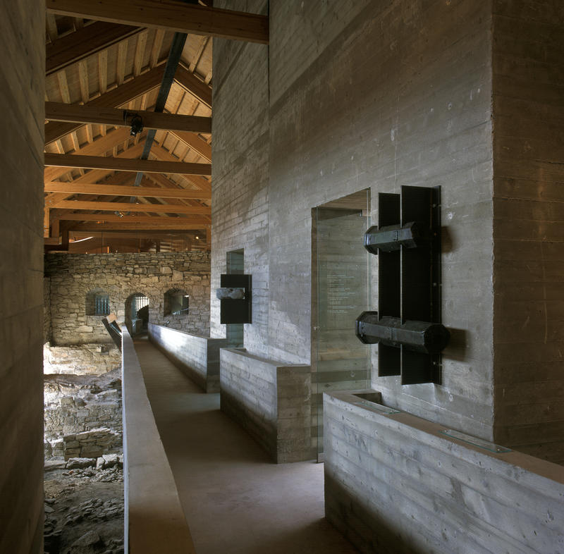 Sverre Fehns betongbro gjennom museets middelalderdel er omkranset av funn fra ruinene etter bispegården, blant annet kanonfragmenter.