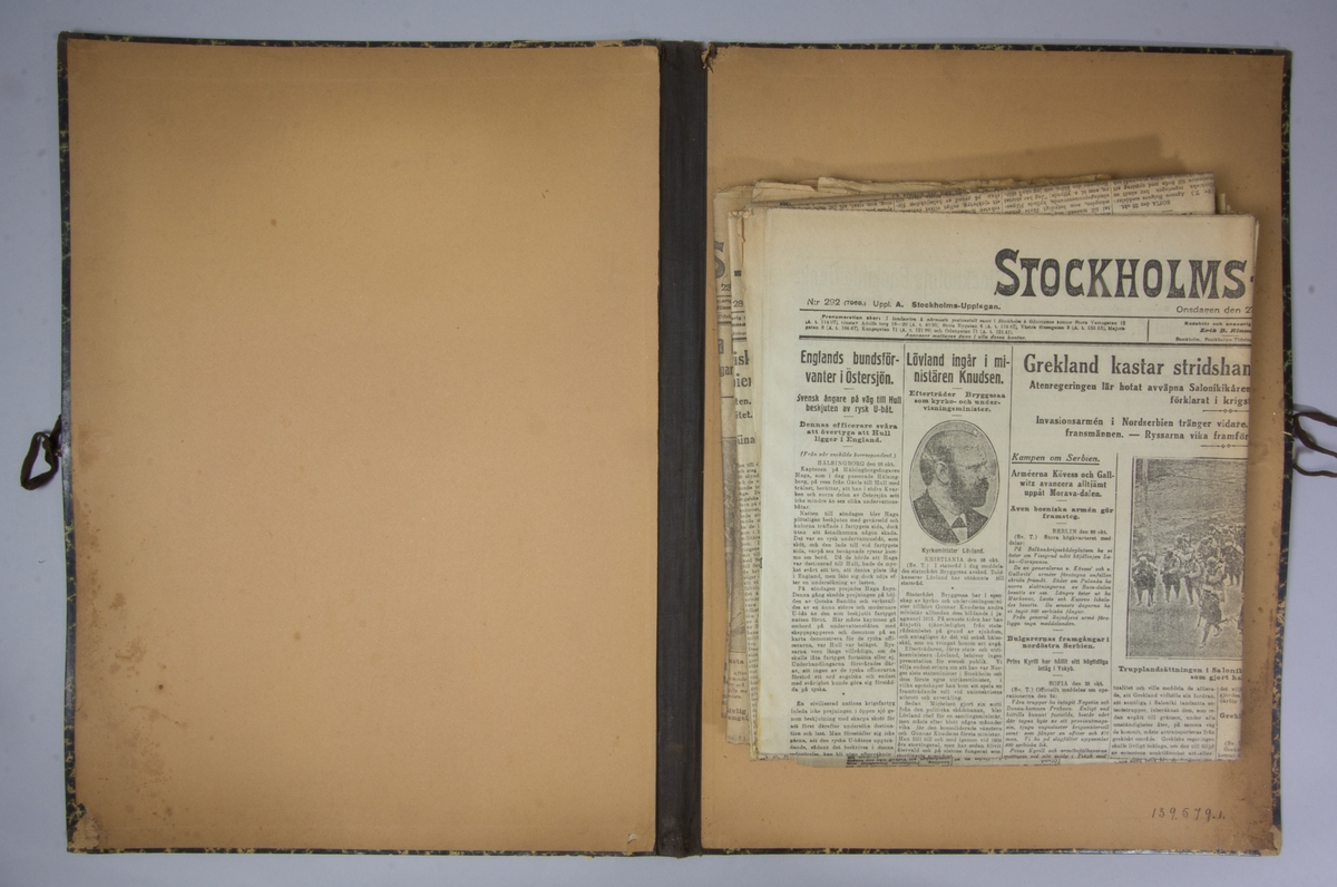 Portfölj av marmorerad papp. Sammanhållen med knytband. Rygg av svart linne. Innehåller enbart flera exemplar av Stockholms Tidningen från 1915.