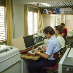 Kontorlandskap. Folk ved dataskjermer.