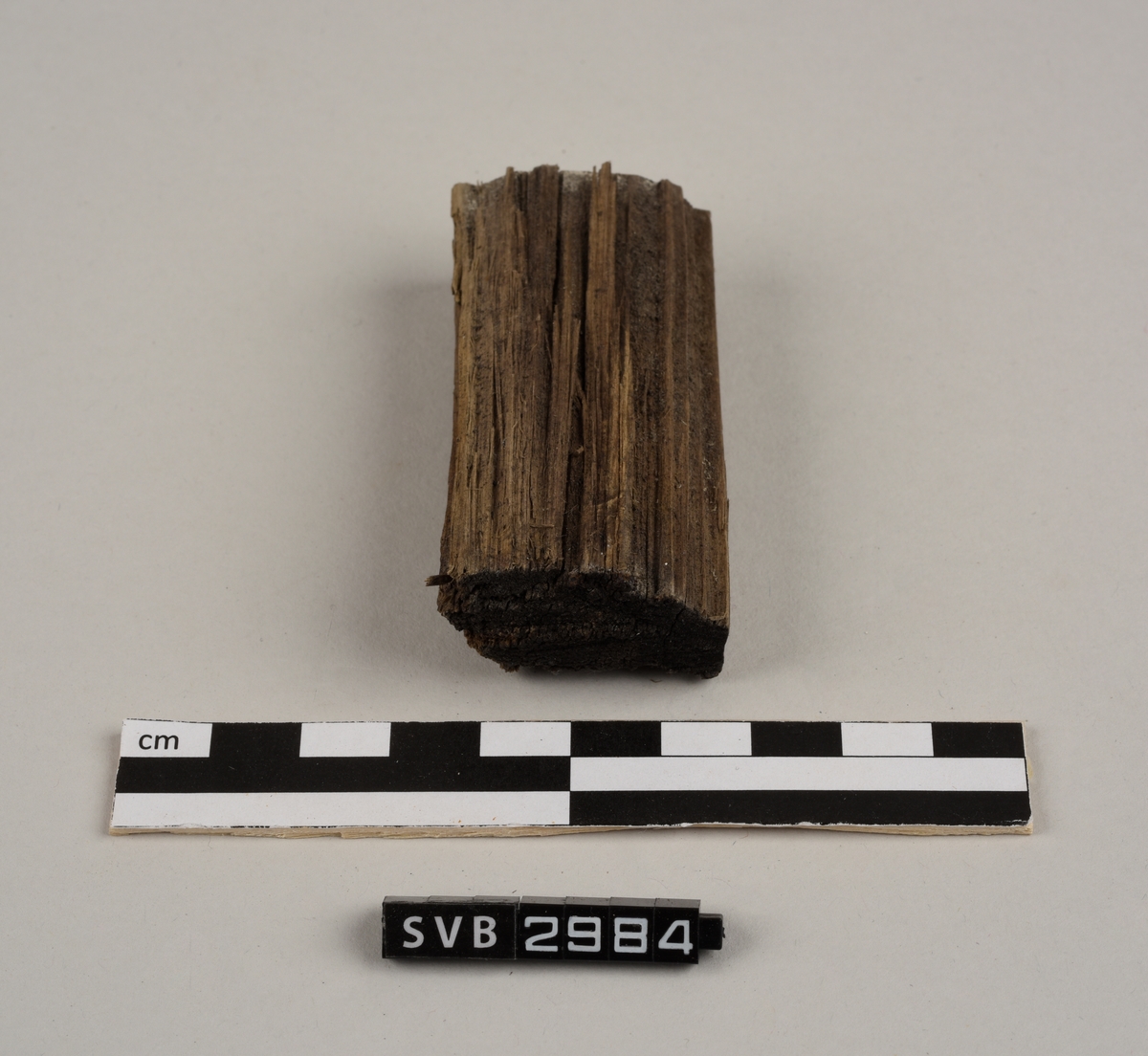 Tregjenstand med tilnærmet rundt tverrsnitt. Tremateriale er tørt og sprukkent. Det er 2 løse deler. Det er en lapp på undersiden med russiske tall og bokstaver.