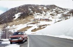 Gård med bil i forgrunnen.