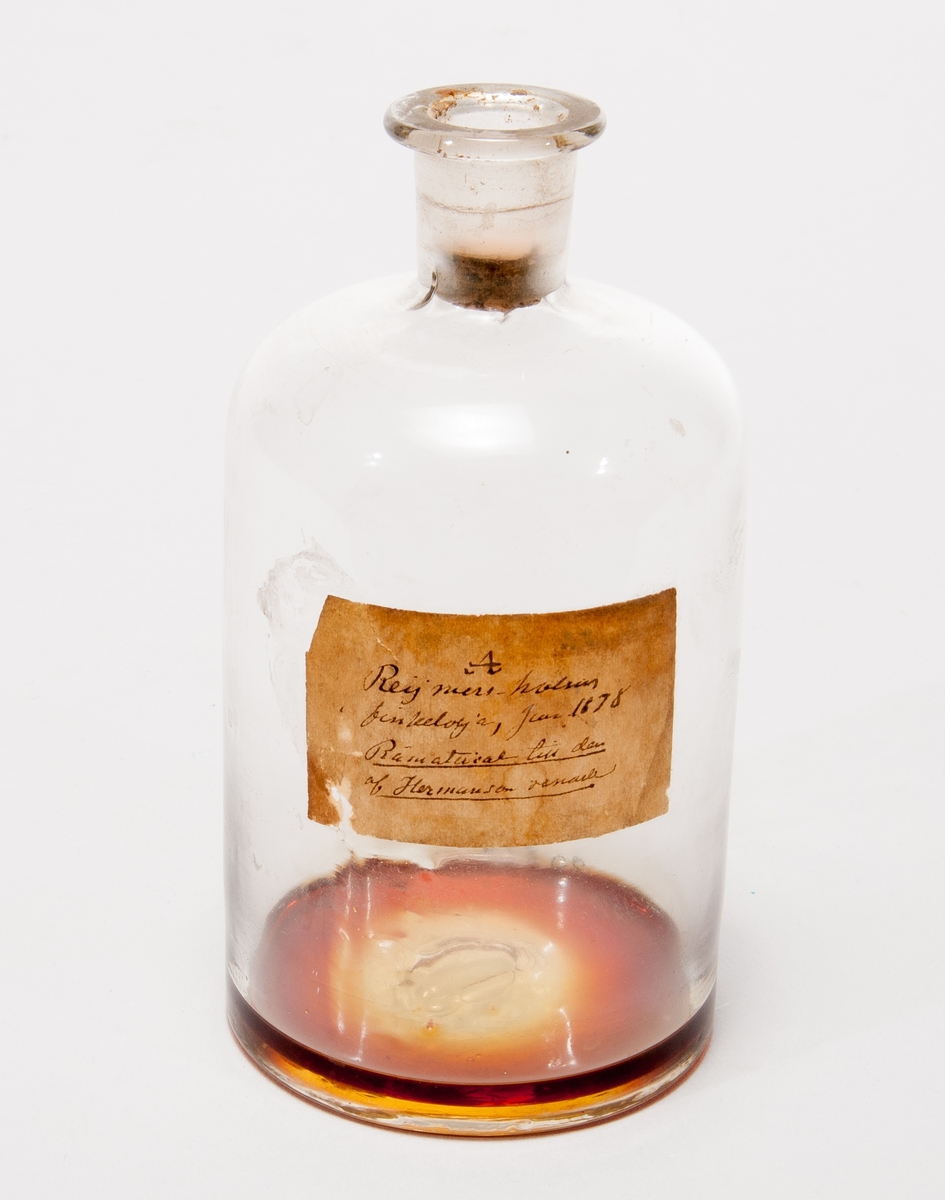 Prov på finkelolja. I flaska av glas med etikett: "A. Reijmers-holms finkelolja, jan 1878. Råmaterial til den af Hermanson renade."