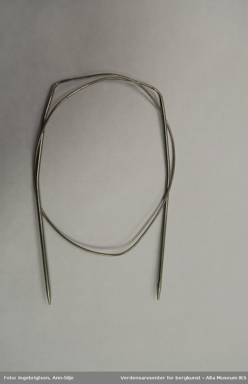 Form: Strikkepinner med en tynn stålwire imellom.