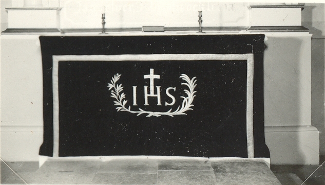 Altare med kandelabrar och kristusmonogram i Loftahammar kyrka.
