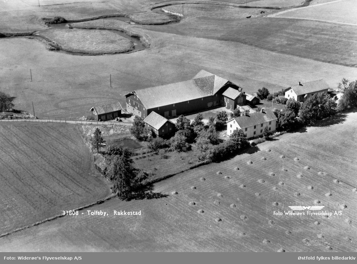 Skråfoto av gården Tolfsby i Rakkestad, juli 1951.