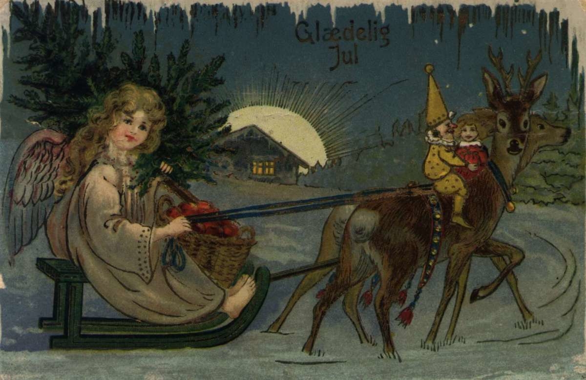 Julekort. Jule- og nyttårshilsen. Engel på kjelke trukket av to hjort (?). To dukker på ryggen til hjortene. Stemplet 18.12.1918.