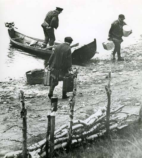 Postbåten har kommit till Keinovuopio 1961. Postmannen och Könkömälappar bär i land varor.
