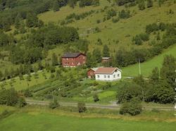 Nørre-Bjøre. Hvitt bolighus, stor hage. Bak stort rødbrunt b