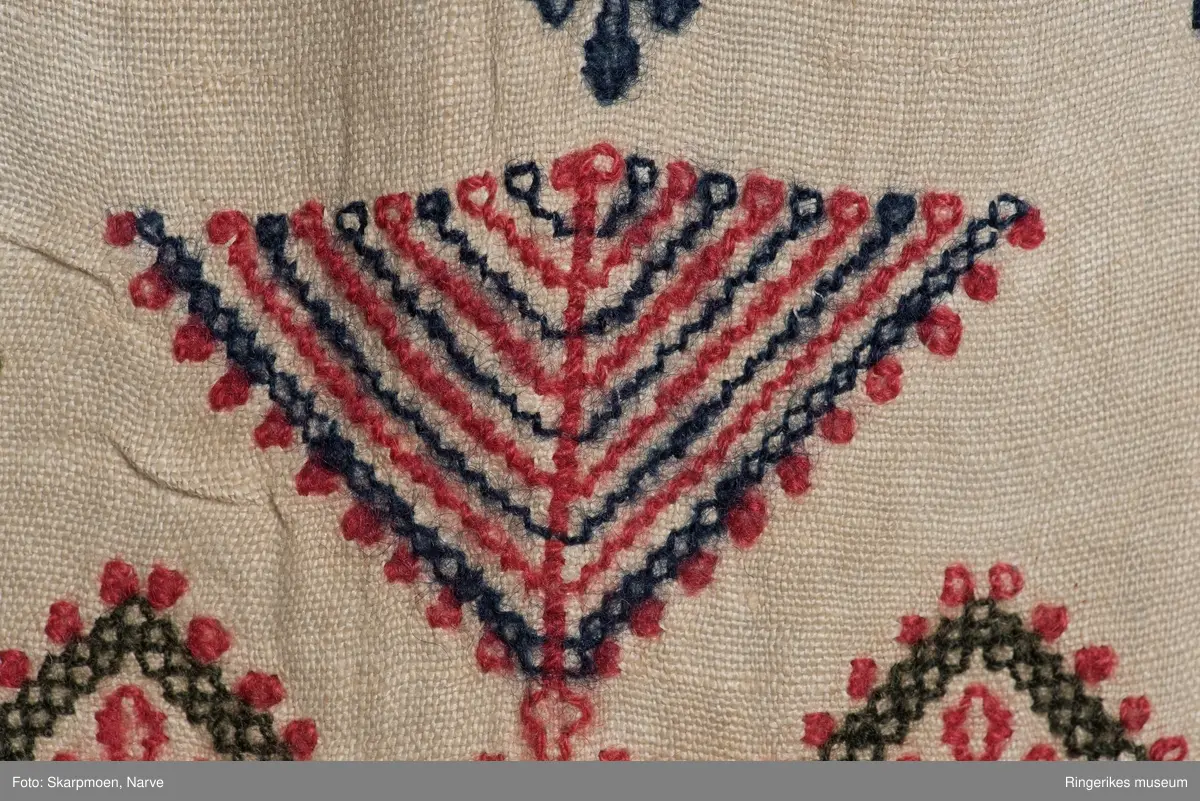 Kvadrater stilt på høykant, små kors og 8 armete staker? Motivene er stilt i rader over hele duken. Gjenombrutt bord med kvadrater i en kortende