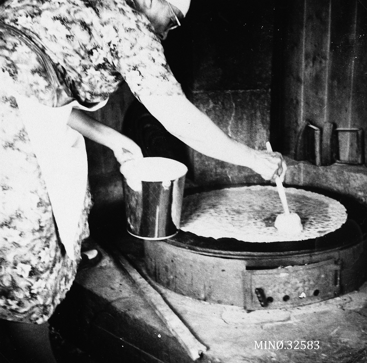 Hilda Hagen smører det ferdigstekte brødet med en blanding av sirup, fløte, sukker og kardemomme