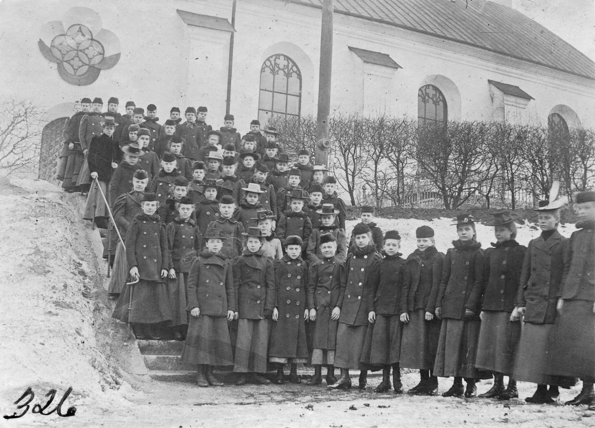 Unga uniformerade flickor utanför Köpings kyrka. Omkring 1900.