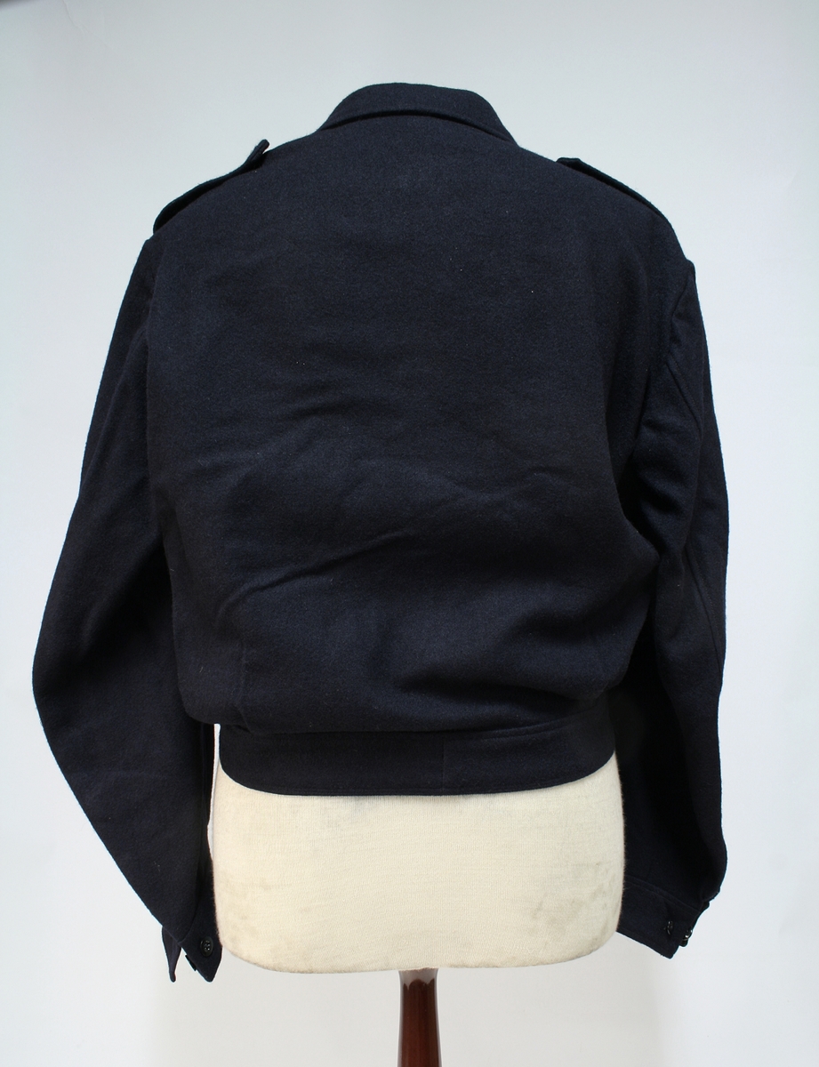 Gylfknappet mørkeblå jakke med innstramming i linningen.