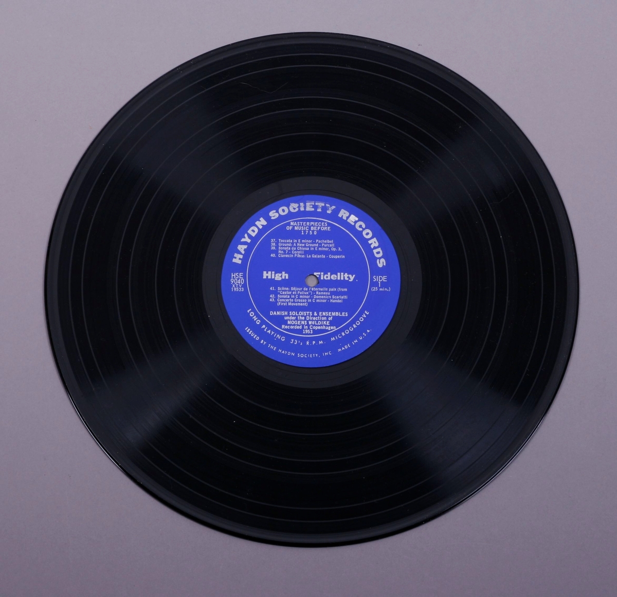 Grammofonplate i svart vinyl og plateomslag i papp. Beskyttelsesplast er framdeles på plateomslaget. Plata ligger i en papirlomme.