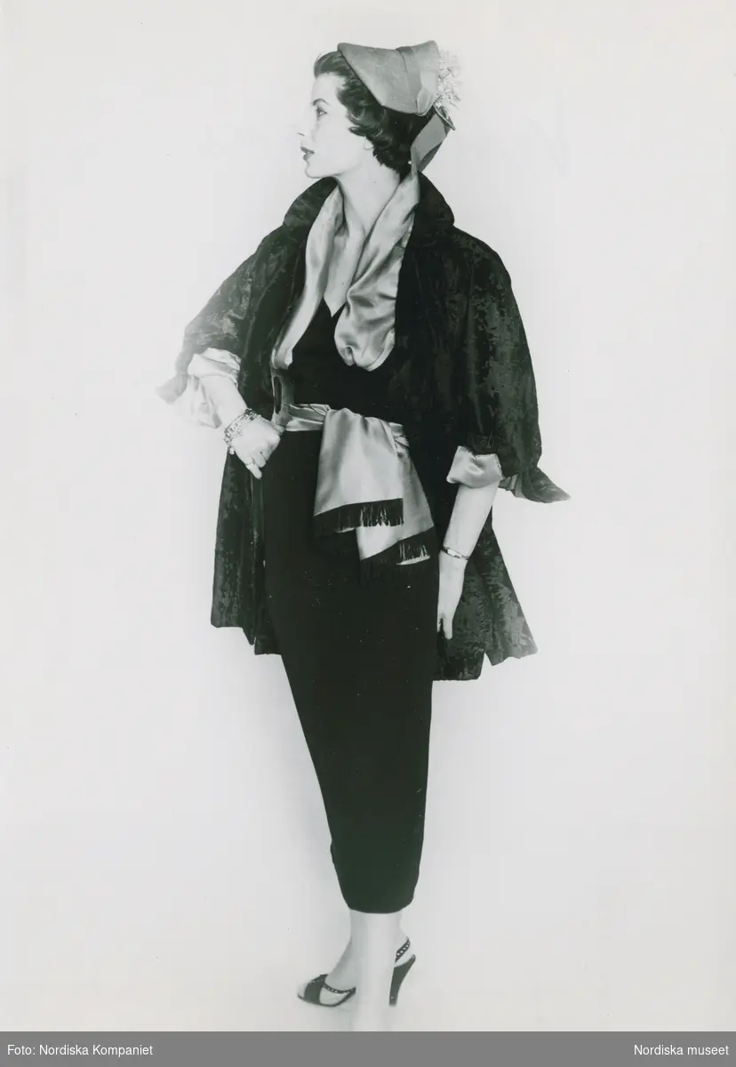 Modell i jacka, silkessjal, kjol, hatt, armband och högklackade skor. "Venezian, Italiana".