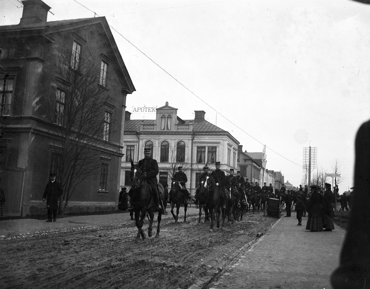Militärparad vid utställningen 1901. Södra Fältskärsgatan, kvarteret Nya Svan till vänster. Apoteket Kronan, kv Gäddan.