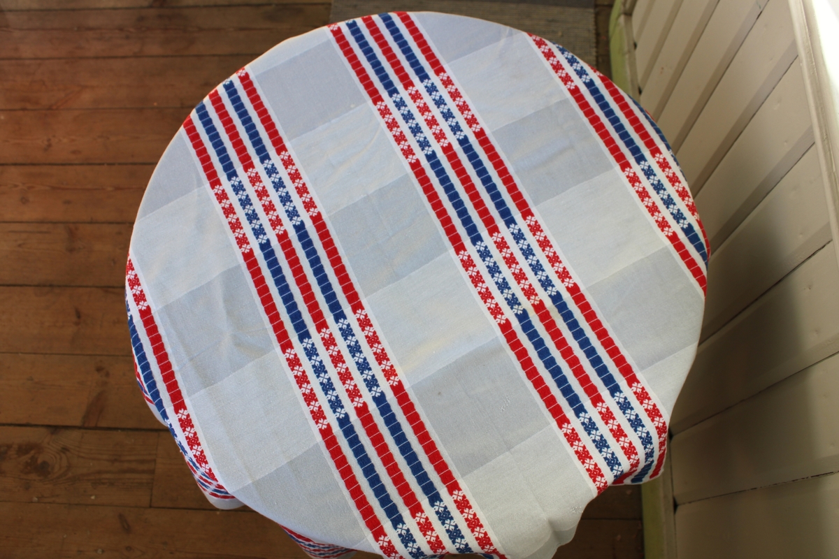 Fyrkantig bordsduk. Grått och vitt rutmönster med blå och röd dekor.