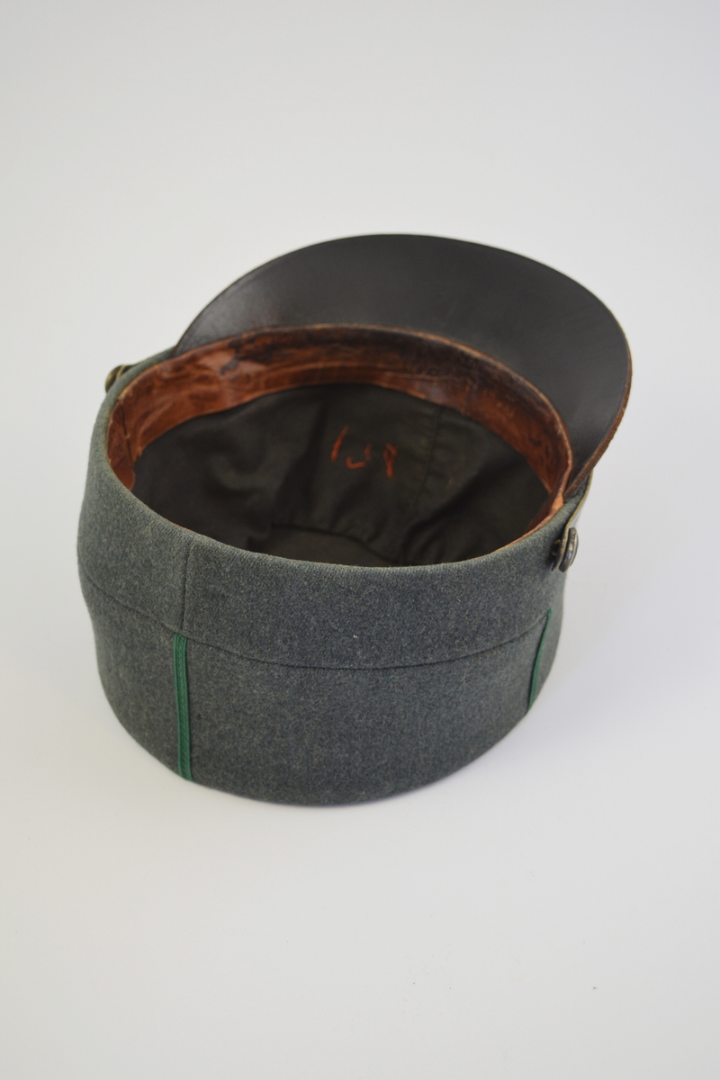 Uniform i tre deler: jakke, lue og patronveske. Innsvinget jakke med fire lommer,enkelt spent,nedbrettet krage. Bøtteformet lue med distinksjoner. Svart lærbrem og svart lærrem som går over bremmen. Kvadratisk patronveske i grønt lerretsstoff, med stor svar trykknapp foran.