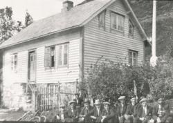 Gruppeportrett av en gjeng unge gutter foran et hus.