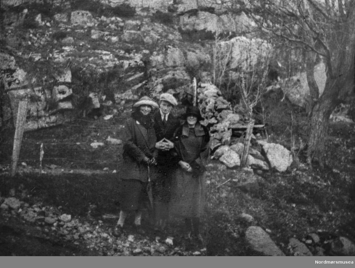 Foto av to kvinner og en mann på skogtur. Det er ukjent hvem vi ser på bildet, men sannsynligvis fra Williamsslekten. Det er ukjent hvor og når bildet er tatt, men trolig omkring 1918-1920.Fra et fotoalbum tilhørende Ellinor Williams-Phakdikun (1905-1963). Fra Nordmøre museums fotosamlinger.