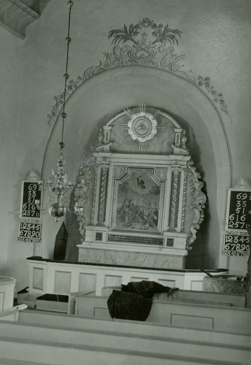Altare, strålsol, psalmtavla och kyrkbänkar i Egby kyrka.