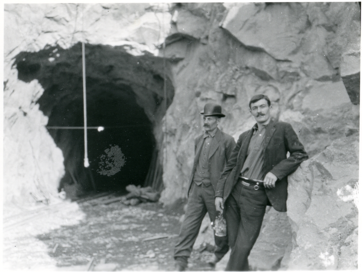To menn står utenfor tunnelinnslaget til Finsandbanen i Ådalen