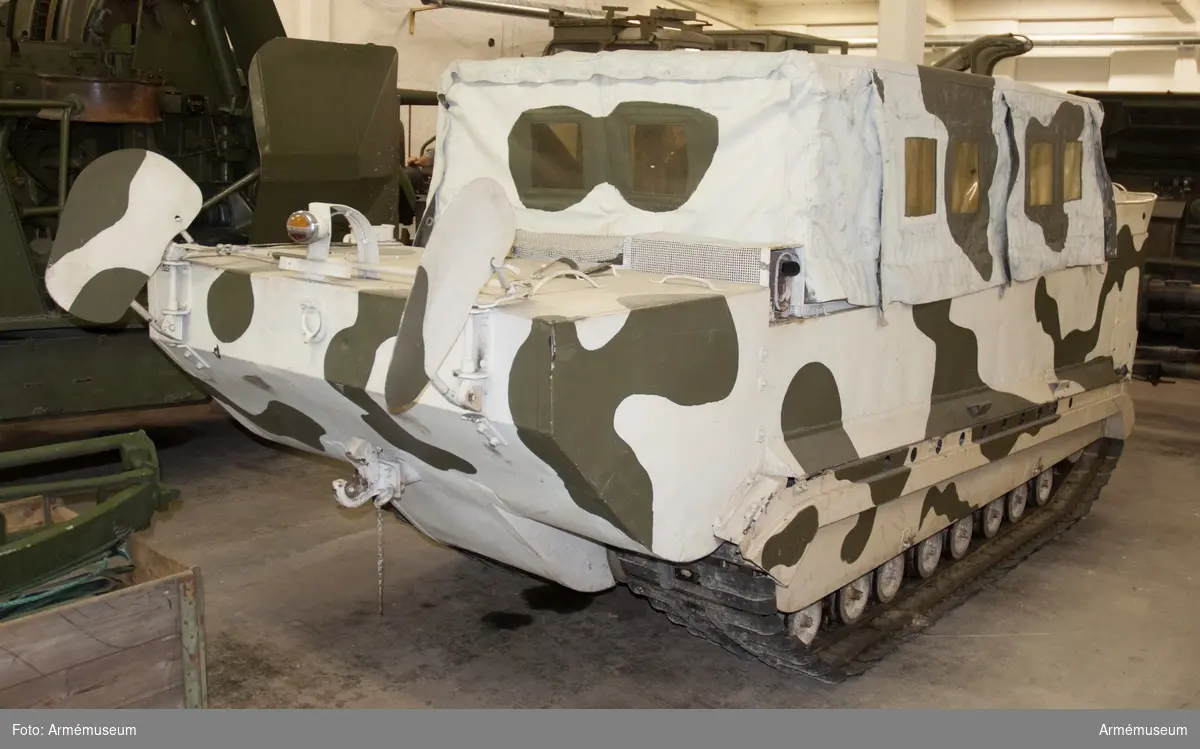 Med flyttankar. Amerikansk beteckning M-29 C. Bandvagnen har tillhört Distriktskommando Tröndelag Norge (se instruktionsbok för WEASEL (Snöbeltevogn M-29 og M-29 C) 1950 (A 110) och Bandvagn m/48).

I vänster fack i fören finns följande tillbehör: 
- låda för kulspruteband, grönmålad av aluminiumplåt för tysk kulspruta MG 34 (jmf AM.004701), men här använd som tillbehörslåda med följande innehåll: 
- generatorrem Optimat 17 made in Germany; 
- fläktrem 3030-517-1134 Belt BA RD-A 860; 
- 2 st tändstift "Blue Crown Husky M-7";
- plåtlåda med skumgummiinredning med 3 st lampor och 2 st säkringar; 
- järntråd;
- 5 st plugg för skrov 3/4" av järn, märkta: fyrkant, S,T,G ring m prick i; - plugg av mässing;
- 12 st saxsprintar i brunt kuvert märkt: 42-P-5347 Splinter ass;
- 4 st träkilar med kedja emellan 2 och de andra två löpande lösa på kedjan; 
- 2 st kedjor med vardera fyra lösa ändar med vinkelhöjda (90 grader) krokar okänd användning, 
- hänglås utan nycklar.

Lösa tillbehör i facket: 
- länspump med slang; 
- domkraft märkt: Drednaut 961 made in USA, med vev; 
- domkraftsfäste för bandspänning (nya typen);
- domkraftsfäste för boggi märkt 41-L-1392;
- domkraftsfäste för boggi märkt 41-L-392 (vinklat järn).

I passagerarutrymmet: Bakom vänstra stolen på sidan en strålkastare (kan fästas på vagnens utsida) märkt: stort C med litet c i, 107406G, på underkant av glaset står BW i mitten av glaset GE (troligen General Electric); 
- 2 st vinkeljärn som passar i hålen på passagerarutrymmets främre vägg, troligen radioanläggning. 

En vit båtshake hänger på vänstra utsidan av vagnen.