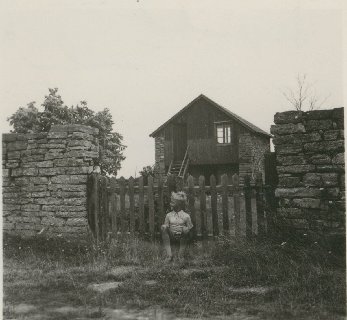 En pojke framför en grind till en gård i Segerstad.