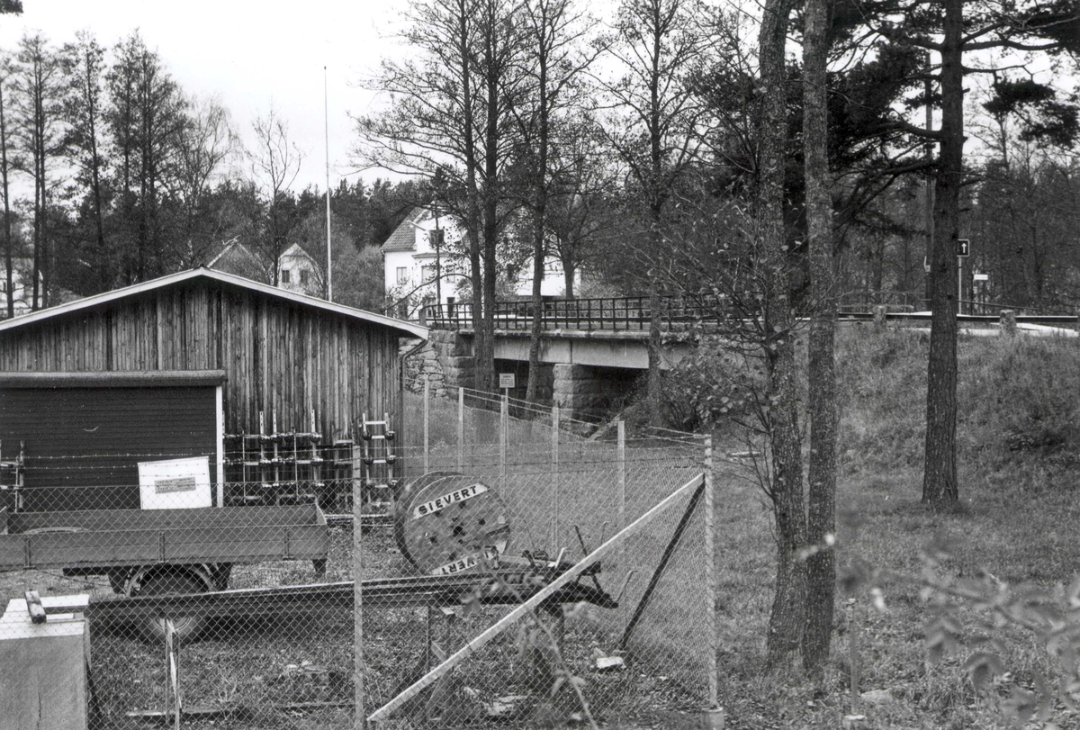 Motiv från Högsby. Ett garage och släpvang. En vägbro i bakgrunden.