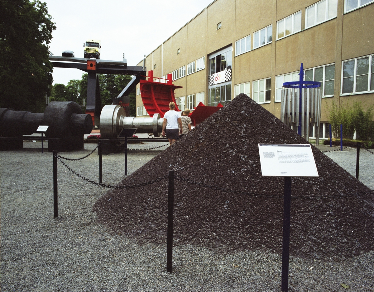 Utställningen "Stålets ansikte".  Pellets (råjärn) hög i förgrunden med rotortrappan och bron i bakgrunden.