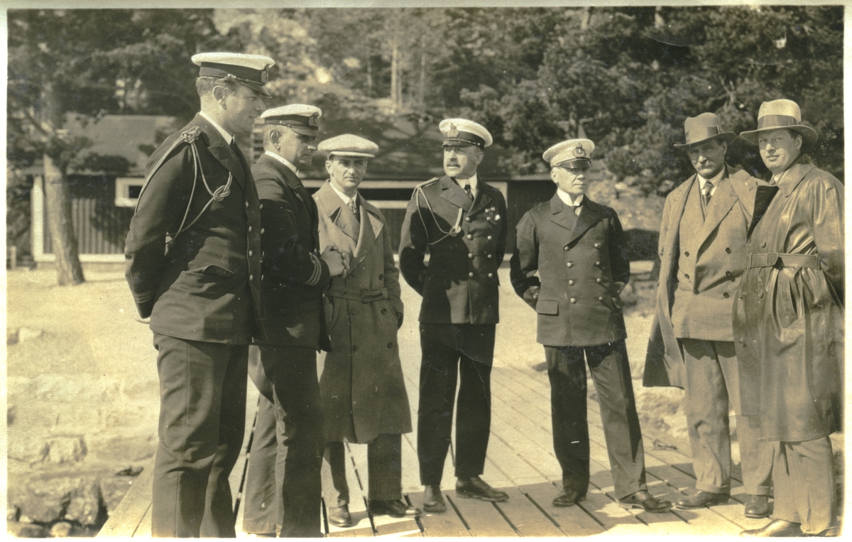 Fyra sjöofficerare och tre civilister på brygga, sammanhanget okänt. De båda officerarna i mitten är till v kommendör Claës Lindsström och till h amiral Harald Åkerman.