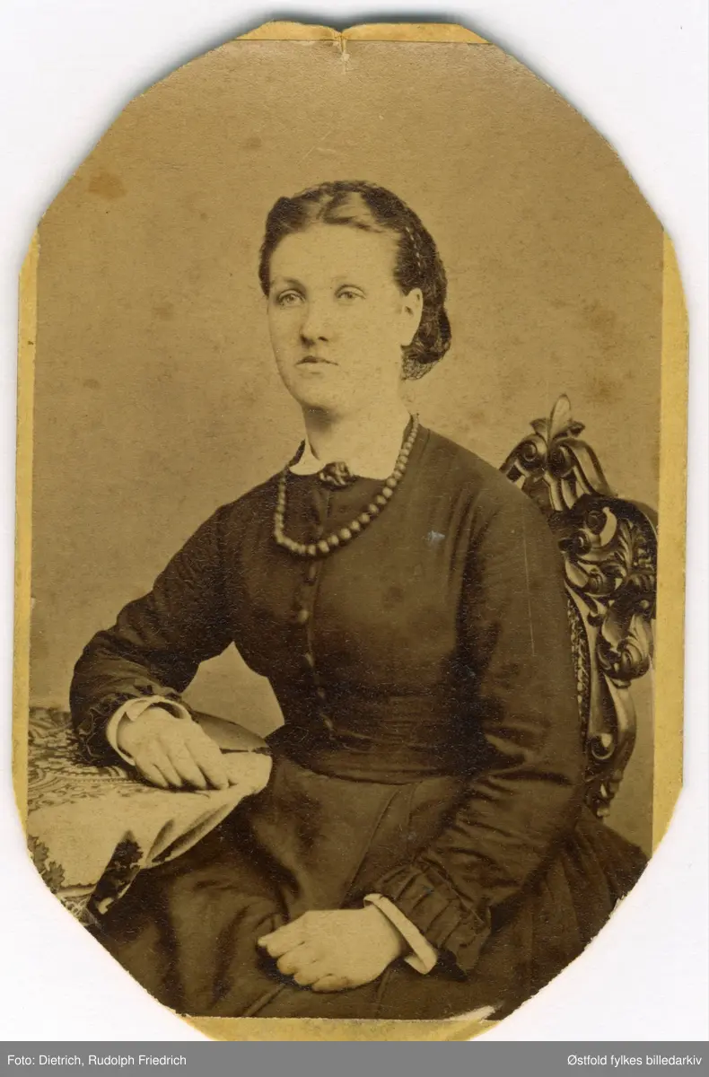Portrett av Andrine Karine Larsdatter Buskoven, født 5. august 1850 på Kråkerøy, døde 27.november 1921. Gravlagt på Kråkerøy kirkegård.

Gift med Ole Christian Augensen, f. 15. april 1849 på Bossum i Onsøy. Ole var skipstømmermann og gårdbruker. 
Andrine og Ole giftet seg 23. oktober 1877 og fikk 8 barn. 
De overtok gården Buskoven (Buskogen) etter Andrines far i 1894.