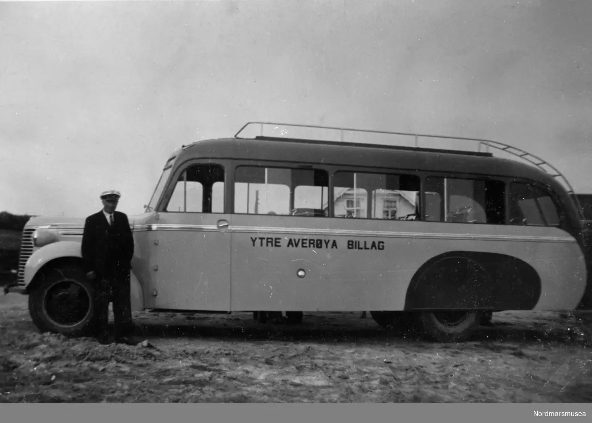 Ytre Averøya Billag A/L ble stiftet 28. desember 1939. Første halvår 1940 ble det praktiske arbeidet startet, med å kjøre ruter Tøvik-Kårvåg-Bremsnes-Kristiansund. Det ble anskaffet bilmateriell. Dette er antakelig første personbuss, Chevrolet 1939-modell som fikk karosseri påbygd hos Brødrene Solheimdal, Solemdalen ved Molde. Bussen hadde 26 sitteplasser og ble registrert T-4354.  Indre Averøya billag ble også startet i 1940. Fra 1. januar 1964 ble selskapene sammenslått under navnet Averøy Billag A/S. Selskapet fikk hovedkontor og verksted ved fergekaia på Bremsnes. Kilde: Over til rutebil: Avdeling Møre og Romsdal 1930-1965. Utgitt av Norges Rutebileieres Forbund, Møre og Romsdal, 1966. (Info: 
Sveinung Berild) --  Buss: Chevrolet 1939. Den ser ganske ny ut. Så bildet kan være førkrigs, og bussen var neppe i drift etter ca. 1955. (Info: Ivar Stav).  Foto av en buss fra "Ytre Averøya Billag". sjåfør med lue. Hvor bildet er tatt er ikke kjent, men kan det være foran bedehuset ved gammelvegen i Kirkevågen på Bremsnes i Averøy kommune?? Ren gjetting... Fra Nordmøre museums fotosamlinger.